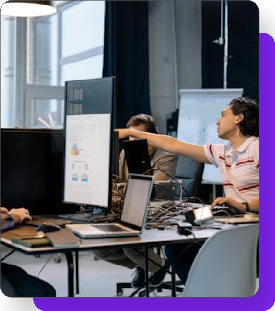 Team members collaborating in a modern office, analyzing data on a computer screen, representing Quixify Media's strategic digital marketing approach.